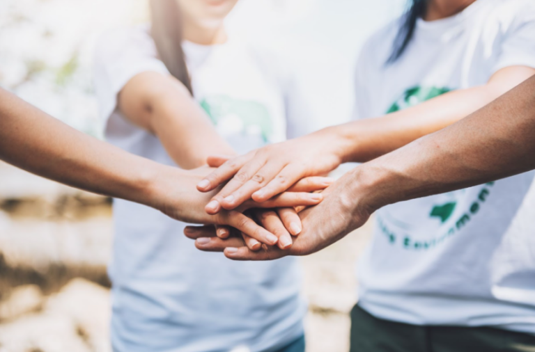Four people's hands stacked on top of each other